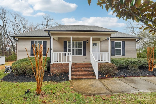 bungalow featuring a porch and roof with shingles