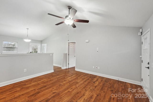 unfurnished room with lofted ceiling, a ceiling fan, baseboards, and wood finished floors