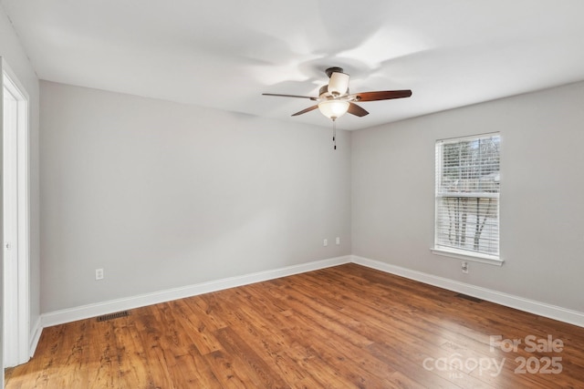 empty room featuring visible vents, baseboards, ceiling fan, and wood finished floors