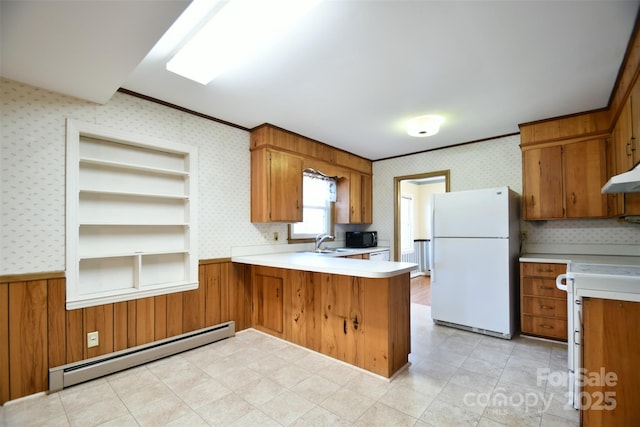 kitchen with wallpapered walls, a baseboard radiator, freestanding refrigerator, a peninsula, and light countertops