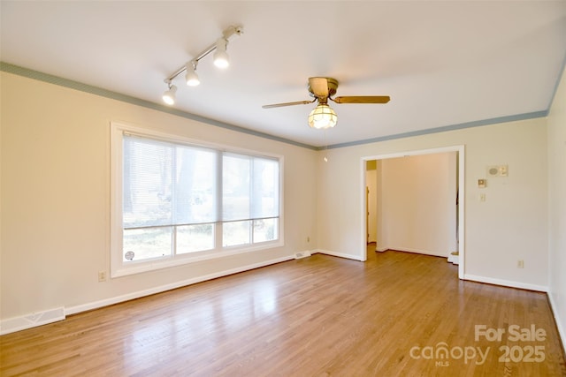 unfurnished room with baseboards, visible vents, a ceiling fan, rail lighting, and light wood-type flooring