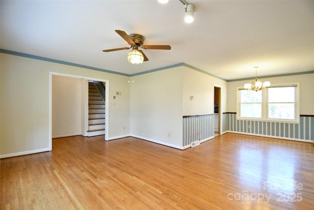 spare room featuring ornamental molding, light wood-style flooring, and baseboards