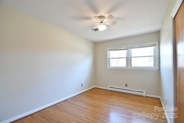 unfurnished room with ceiling fan, a baseboard heating unit, visible vents, baseboards, and light wood-type flooring