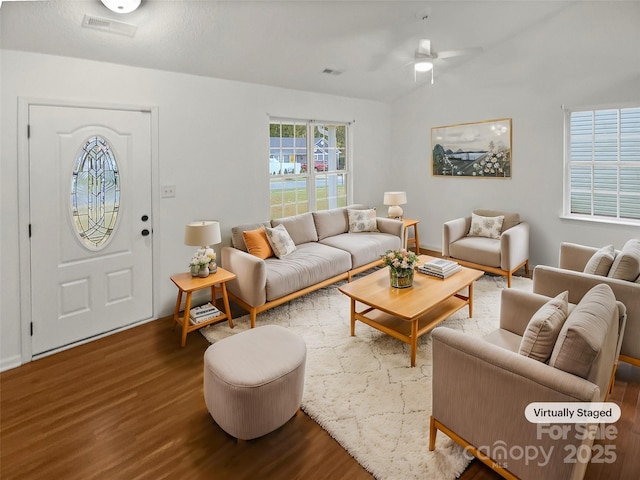 living area with visible vents and wood finished floors