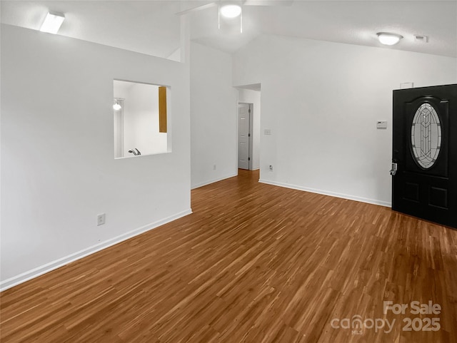 foyer entrance featuring lofted ceiling, a ceiling fan, baseboards, and wood finished floors