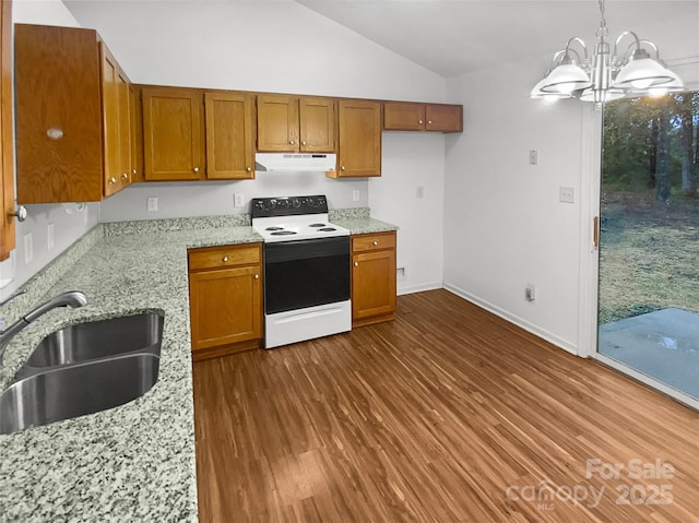 kitchen with light stone counters, electric range, brown cabinetry, a sink, and under cabinet range hood