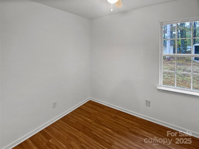 empty room featuring dark wood-style floors, ceiling fan, and baseboards