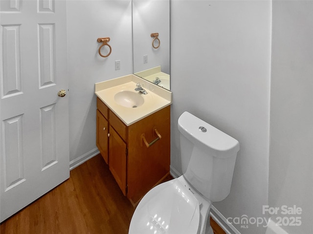 bathroom with vanity, toilet, and wood finished floors