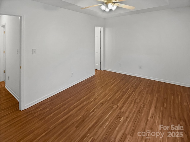 spare room featuring a ceiling fan, baseboards, and wood finished floors