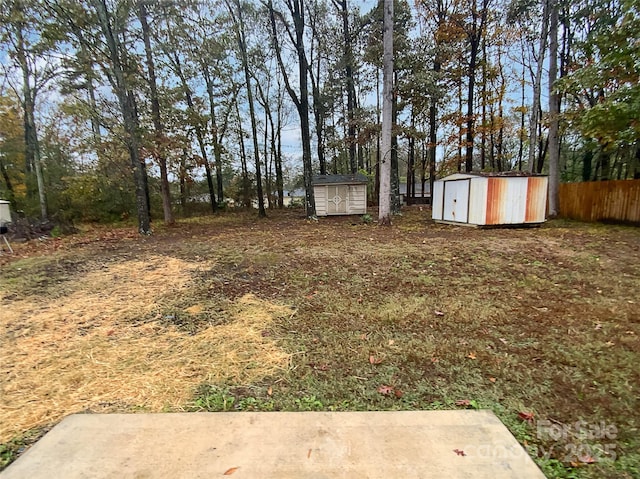 view of yard with a shed, fence, and an outdoor structure