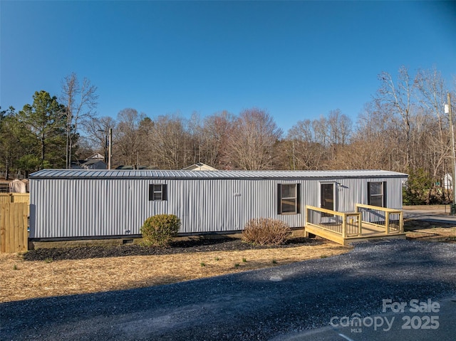 view of front facade featuring a standing seam roof, metal roof, crawl space, and board and batten siding