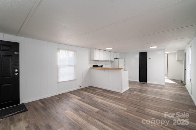 interior space with wood finished floors and baseboards