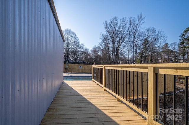 wooden terrace with a fenced in pool