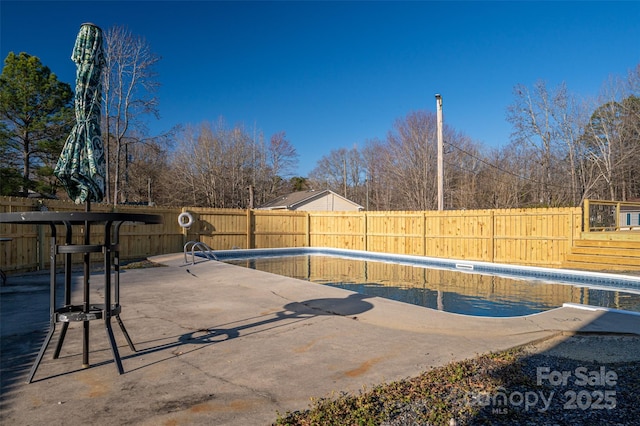 view of swimming pool featuring a patio area, a fenced backyard, and a fenced in pool