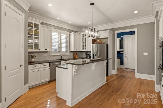 kitchen featuring glass insert cabinets, dark countertops, appliances with stainless steel finishes, and white cabinets