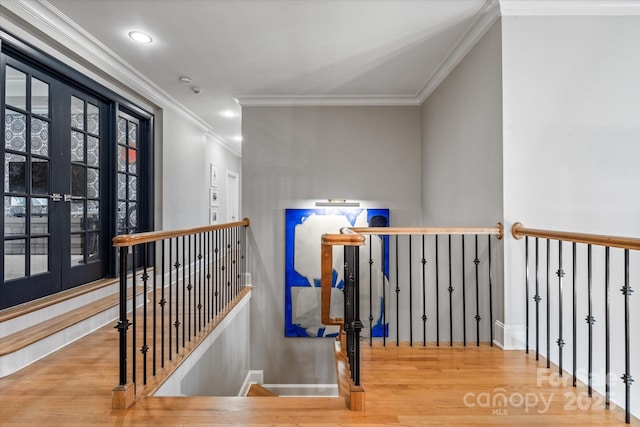 corridor featuring baseboards, crown molding, an upstairs landing, and wood finished floors