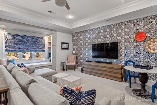 living room with ornamental molding, visible vents, baseboards, and a ceiling fan