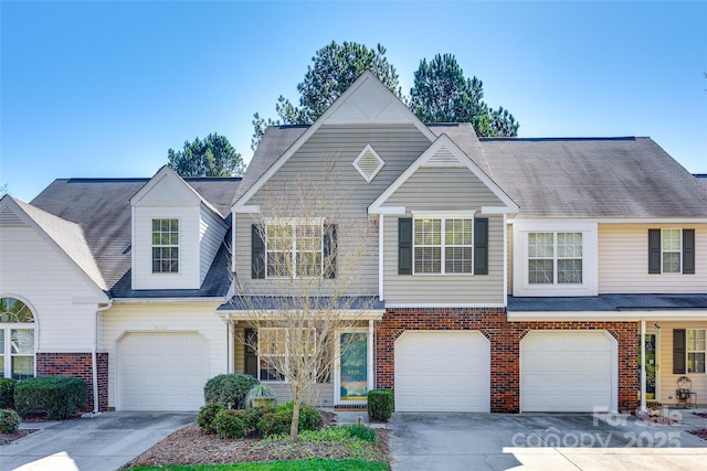 view of property with brick siding, driveway, and an attached garage