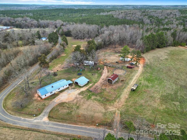 bird's eye view with a wooded view and a rural view