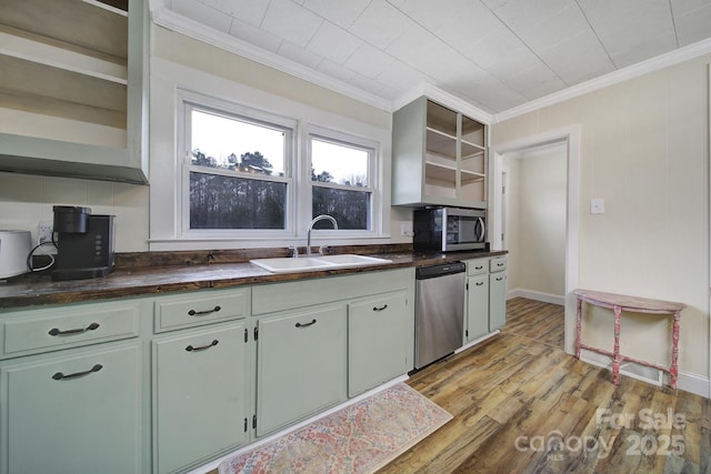 kitchen featuring light wood finished floors, open shelves, stainless steel appliances, dark countertops, and a sink