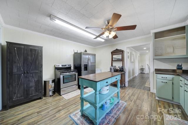 kitchen featuring ceiling fan, light wood-style flooring, appliances with stainless steel finishes, open shelves, and crown molding