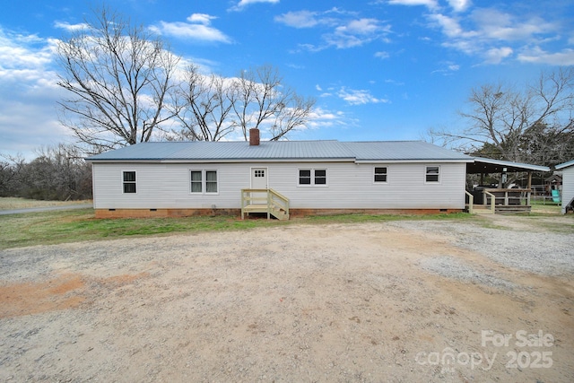 view of front of property with driveway, crawl space, metal roof, and a chimney