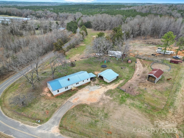 birds eye view of property featuring a rural view and a view of trees