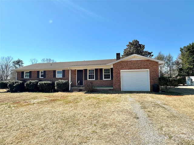 ranch-style house with an attached garage, brick siding, driveway, a chimney, and a front yard