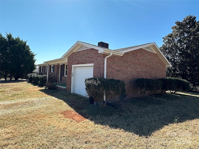 view of property exterior with a garage, brick siding, a yard, and a chimney