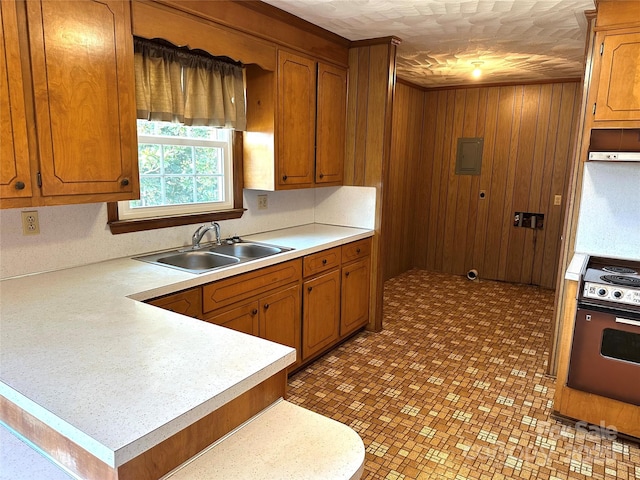 kitchen featuring range, brown cabinetry, light countertops, and a sink