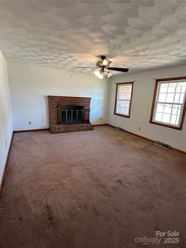 unfurnished living room with visible vents, a fireplace, and carpet flooring