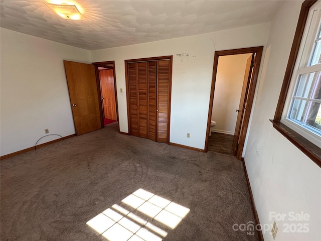 unfurnished bedroom with carpet floors, a closet, and baseboards