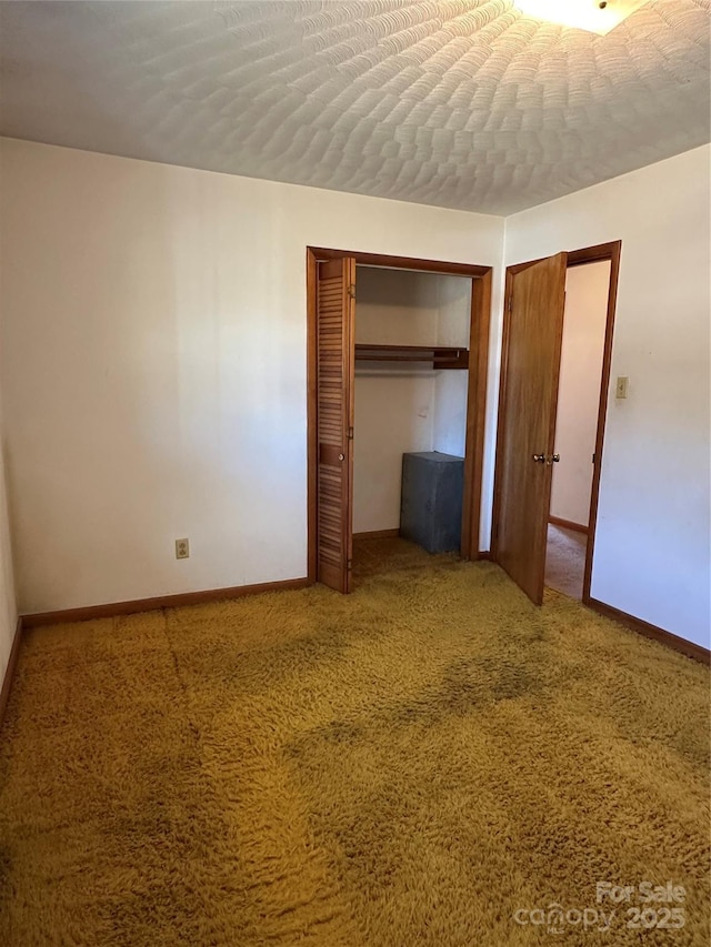 unfurnished bedroom with carpet floors, a closet, and baseboards