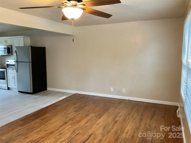 unfurnished room featuring light wood-style flooring, baseboards, and ceiling fan