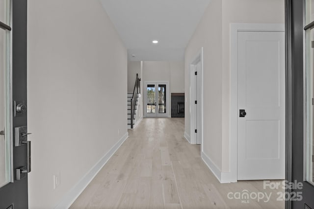 hall featuring stairs, recessed lighting, light wood-style flooring, and baseboards