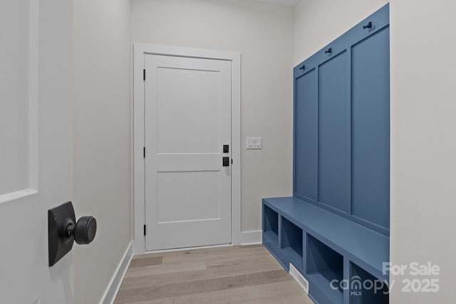 mudroom featuring light wood-style flooring and baseboards