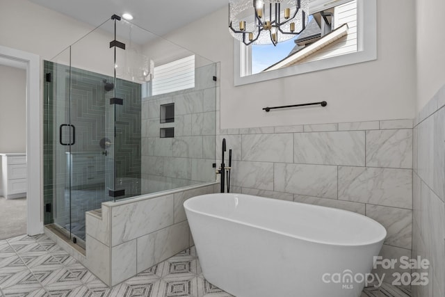 full bathroom with a freestanding tub, a shower stall, and tile walls