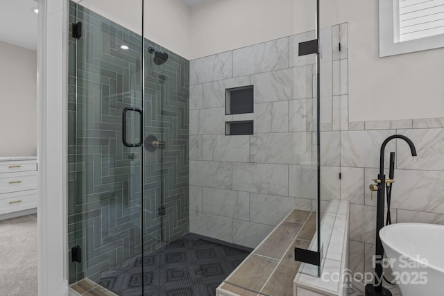 bathroom featuring a freestanding tub, tile walls, and a stall shower