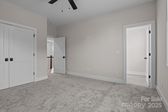 unfurnished bedroom featuring a closet, light carpet, ceiling fan, and baseboards