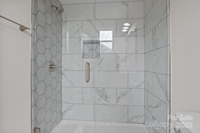 bathroom with toilet and tiled shower