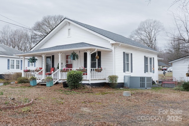 bungalow-style home featuring central AC, a porch, and a shingled roof