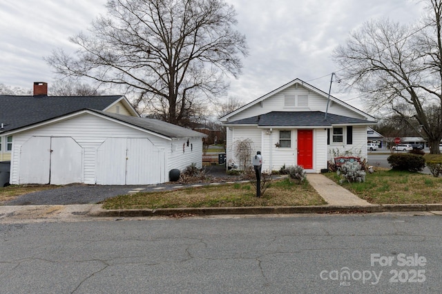 bungalow-style home with roof with shingles