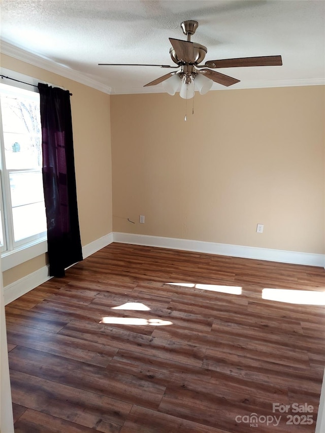 spare room with baseboards, a ceiling fan, ornamental molding, dark wood-style flooring, and a textured ceiling