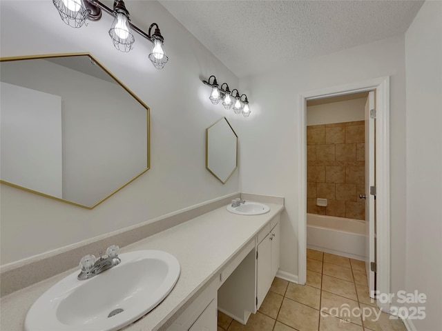 bathroom featuring a textured ceiling, double vanity, tile patterned flooring, and a sink