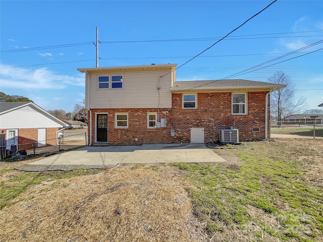 back of property featuring a lawn, fence, cooling unit, a patio area, and brick siding