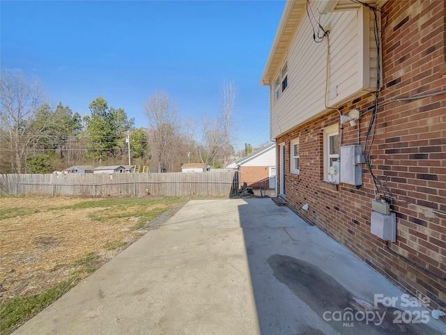 exterior space with a patio area, brick siding, and fence