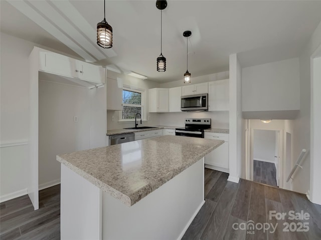 kitchen featuring dark wood-style flooring, stainless steel appliances, light countertops, white cabinetry, and a sink