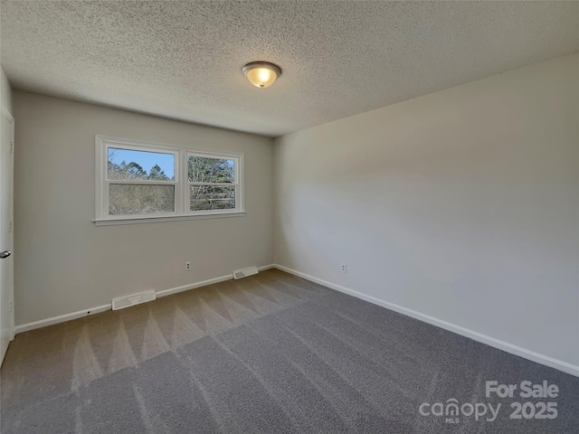 carpeted empty room with a textured ceiling, visible vents, and baseboards