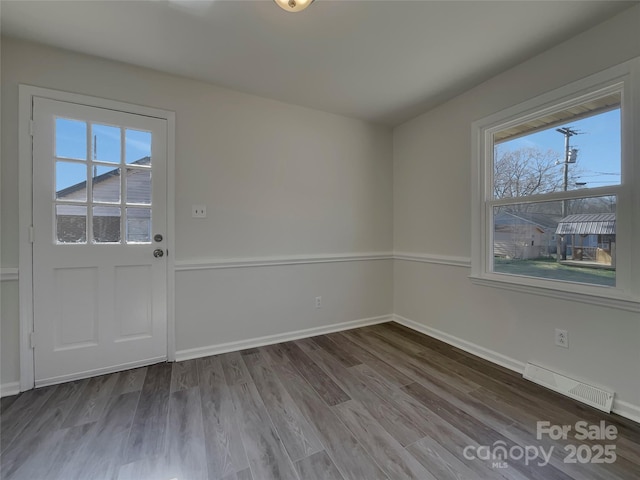 interior space featuring baseboards, visible vents, and wood finished floors