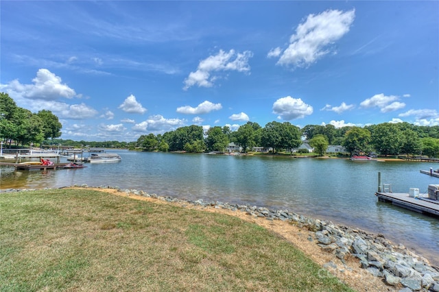 dock area with a water view and a lawn